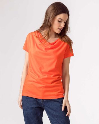 Frau trägt Shirt von SKFK (BAT) aus Biobaumwolle mit kurzen Ärmeln und Wasserfall-Ausschnitt. GOTS und Fairtrade zertifiziert. / Orange / Vorderansicht / pussyGALORE / Leipzig